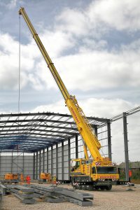 Crane being used to lift steel beams into place on new building