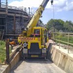 Crane being used to manoeuvre large building materials