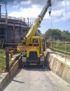 Crane being used to manoeuvre large building materials